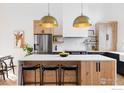 Modern kitchen features custom cabinets, stainless appliances, and a spacious island with seating at 4046 Niblick Dr, Longmont, CO 80503