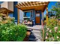 Inviting covered front porch with outdoor seating amid a colorful garden setting at 4661 14Th St, Boulder, CO 80304