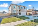 A two-story home featuring a neutral exterior, stone accents, a well-kept lawn, and a two-car garage at 4732 Windmill Dr, Brighton, CO 80601
