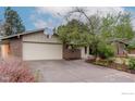 Welcoming home exterior with brick accents, basketball hoop, and driveway leading to the attached garage at 4760 Harrison Ave, Boulder, CO 80303