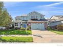 Attractive two-story home with a manicured lawn, flower boxes, and inviting curb appeal at 6317 Ruby Hill Dr, Frederick, CO 80516