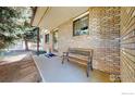 Inviting front porch featuring a brick facade and bench at 729 Jay Pl, Berthoud, CO 80513
