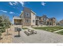 Exterior view of townhomes with a picnic table and grill on common ground for outdoor gatherings at 799 Robert St, Longmont, CO 80503