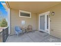 Inviting front porch featuring wicker seating, a small table, and a decorative welcome mat at 799 Robert St, Longmont, CO 80503