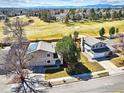 Aerial view of property showing well-manicured lawn, mature trees, solar panels, and proximity to a golf course at 8403 Chase Dr, Arvada, CO 80003