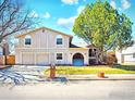 Charming two-story home featuring a well-maintained lawn, mature trees, and a three-car garage at 8403 Chase Dr, Arvada, CO 80003