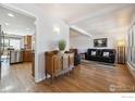 Cozy living room with hardwood floors, a comfortable leather sofa, and an antique wooden dresser at 8403 Chase Dr, Arvada, CO 80003