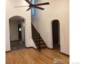 Inviting entrance with hardwood floors, a striking staircase, and arched doorways at 843 Sumner St, Longmont, CO 80501