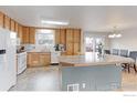 Bright kitchen features wood cabinets and an eat-in area with sliding glass doors at 10538 Quivas St, Northglenn, CO 80234