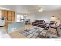 Cozy living room features an open floor plan, wood floors, and comfortable leather seating at 10538 Quivas St, Northglenn, CO 80234