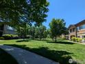 Expansive green space offers a serene community setting with mature trees and manicured lawns at 1122 Olympia Ave # 12H, Longmont, CO 80504