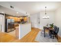 Open kitchen with stainless steel appliances, breakfast bar, and adjoining dining area, great for entertaining at 1122 Olympia Ave # 12H, Longmont, CO 80504
