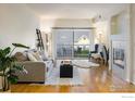 Bright living room featuring hardwood floors, a cozy fireplace, and sliding glass doors to a balcony at 1122 Olympia Ave # 12H, Longmont, CO 80504