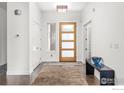 Bright foyer with light walls, hardwood floors, and a modern wooden front door at 1135 Redwood Ave, Boulder, CO 80304