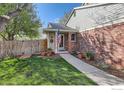 Charming front exterior with a well-kept lawn, flowers, brick accents, and a welcoming entrance at 12342 Milwaukee Ct, Thornton, CO 80241