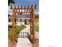 Inviting front entrance with a wooden pergola, a walkway and a beautifully landscaped yard at 14117 W 58Th Pl, Arvada, CO 80004