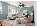 Cozy living room with hardwood floors, neutral decor, a ceiling fan, and natural light at 14117 W 58Th Pl, Arvada, CO 80004