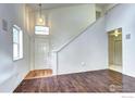 View of the front door and staircase with hardwood flooring and a hanging light fixture at 1438 Stockton Dr, Erie, CO 80516