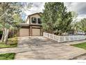 Charming two-story home featuring a two-car garage, white picket fence, and mature landscaping at 1438 Stockton Dr, Erie, CO 80516