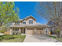 Inviting two-story home with a stone facade, covered porch, mature trees and a two car garage at 1602 Prairie Song Pl, Longmont, CO 80504