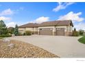 Long driveway leading to an attached three car garage surrounded by decorative rock at 1868 Preserve Dr, Berthoud, CO 80513