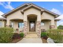 Inviting front entrance featuring stone columns, a tiled porch, and seating at 1868 Preserve Dr, Berthoud, CO 80513