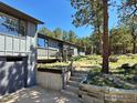 Charming mountain home with a porch entrance and tiered stairs, set amidst natural landscaping at 191 Alder Ln, Boulder, CO 80304
