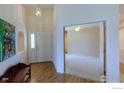 Welcoming foyer with hardwood floors, arched doorway, and a bench, leading into the living spaces at 1930 N Shore Dr, Longmont, CO 80503
