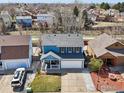 Aerial view of the two-story home showcasing the landscaping, roof and neighborhood at 21112 E 45Th Ave, Denver, CO 80249