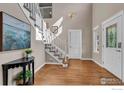 Bright foyer with hardwood floors, staircase, and decorative details at 227 Mckinley Park Ln, Louisville, CO 80027