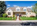 Charming two-story home boasts a covered porch, well-maintained lawn, and mature landscaping at 227 Mckinley Park Ln, Louisville, CO 80027
