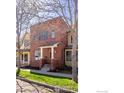Charming two-story brick home featuring a welcoming front porch and well-manicured lawn at 2302 Spruce St, Boulder, CO 80302