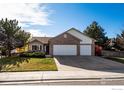 Inviting home featuring a well-kept lawn, mature trees, and attached two-car garage at 2344 Flagstaff Dr, Longmont, CO 80504