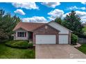 Charming home featuring a brick facade, three-car garage, and well-manicured lawn at 2344 Flagstaff Dr, Longmont, CO 80504