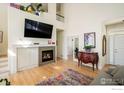 Spacious living room featuring a fireplace, large TV, and hardwood floors for a comfortable ambiance at 2758 Meadow Mountain Trl, Lafayette, CO 80026