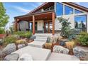 Striking modern home with stone accents, lush landscaping, and covered front porch entrance at 2790 Stanford Ave, Boulder, CO 80305