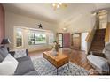 Bright living room featuring wood floors, large windows, and a cozy seating area at 3761 Anvil Ct, Mead, CO 80542