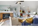 Open-concept living area featuring a brick fireplace, stairs, and adjoined kitchen and dining space at 3812 Howe Ct, Boulder, CO 80301