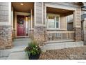 Charming front porch with stone accents and a welcoming red door at 4967 S Ukraine St, Aurora, CO 80015