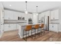 Modern white kitchen with stainless steel appliances and granite countertops at 4967 S Ukraine St, Aurora, CO 80015