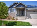 Home with solar panels, stone accents, and covered front porch at 5659 Viewpoint Ave, Firestone, CO 80504