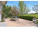 Cozy patio with outdoor dining set surrounded by mature trees and lush landscaping at 665 Glenarbor Cir, Longmont, CO 80504