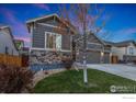 Charming home with stone accents, a well-manicured lawn, and a three-car garage at 719 Wagon Bend Rd, Berthoud, CO 80513