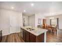 Open concept kitchen with a granite island, stainless steel appliances, and wood flooring at 7225 Shavano Ave, Frederick, CO 80504