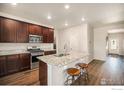 Modern kitchen with granite countertops, stainless steel appliances, and wooden barstools at 7225 Shavano Ave, Frederick, CO 80504
