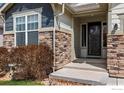 Inviting front entrance with stone accents and a well-maintained landscape at 850 Prairiestar Dr, Berthoud, CO 80513
