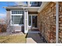 Inviting entrance with stone accents, a manicured lawn, and a well-lit walkway at 9436 Cody Dr, Broomfield, CO 80021