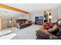 Open-concept living room featuring cozy leather seating and a staircase to upper level at 9655 W 105Th Way, Broomfield, CO 80021