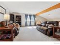 Spacious living room featuring large windows, beamed ceiling, and comfortable leather furniture at 9655 W 105Th Way, Broomfield, CO 80021