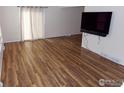 Bright living room with laminate wood floors and a modern entertainment center at 1015 Alta St, Longmont, CO 80501